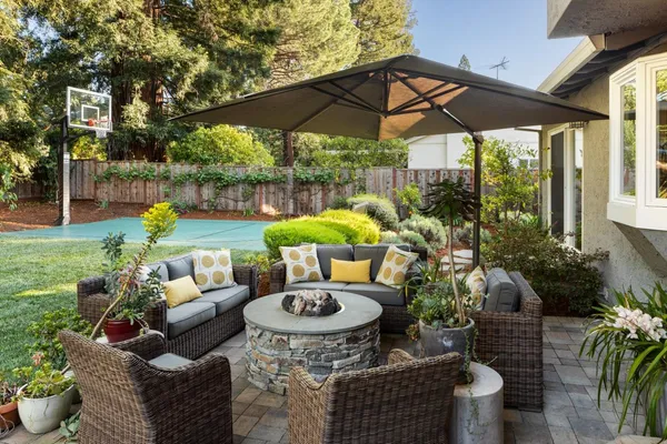 a view of a patio with table and chairs potted plants and a palm tree