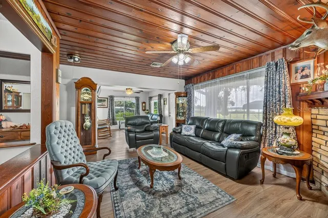 a living room with furniture a chandelier and a dining table