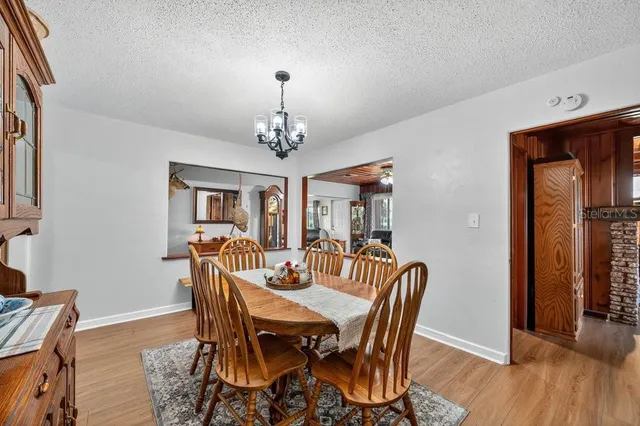a view of a dining room with furniture wooden floor and chandelier