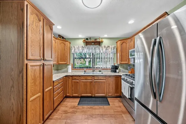 a kitchen with stainless steel appliances granite countertop a refrigerator and a sink