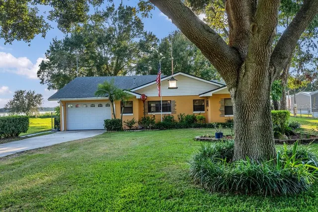 a front view of a house with yard and green space
