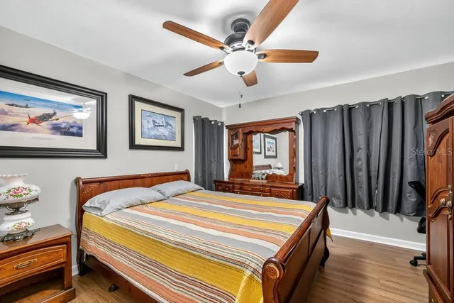 a bedroom with bed and wooden floor