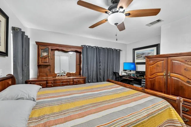 a bedroom with a bed a dresser and a chandelier