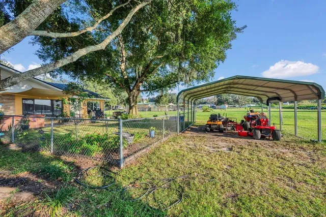 a view of a park with table and chairs under an umbrella