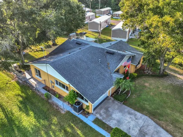 an aerial view of a house with a yard swimming pool and outdoor seating