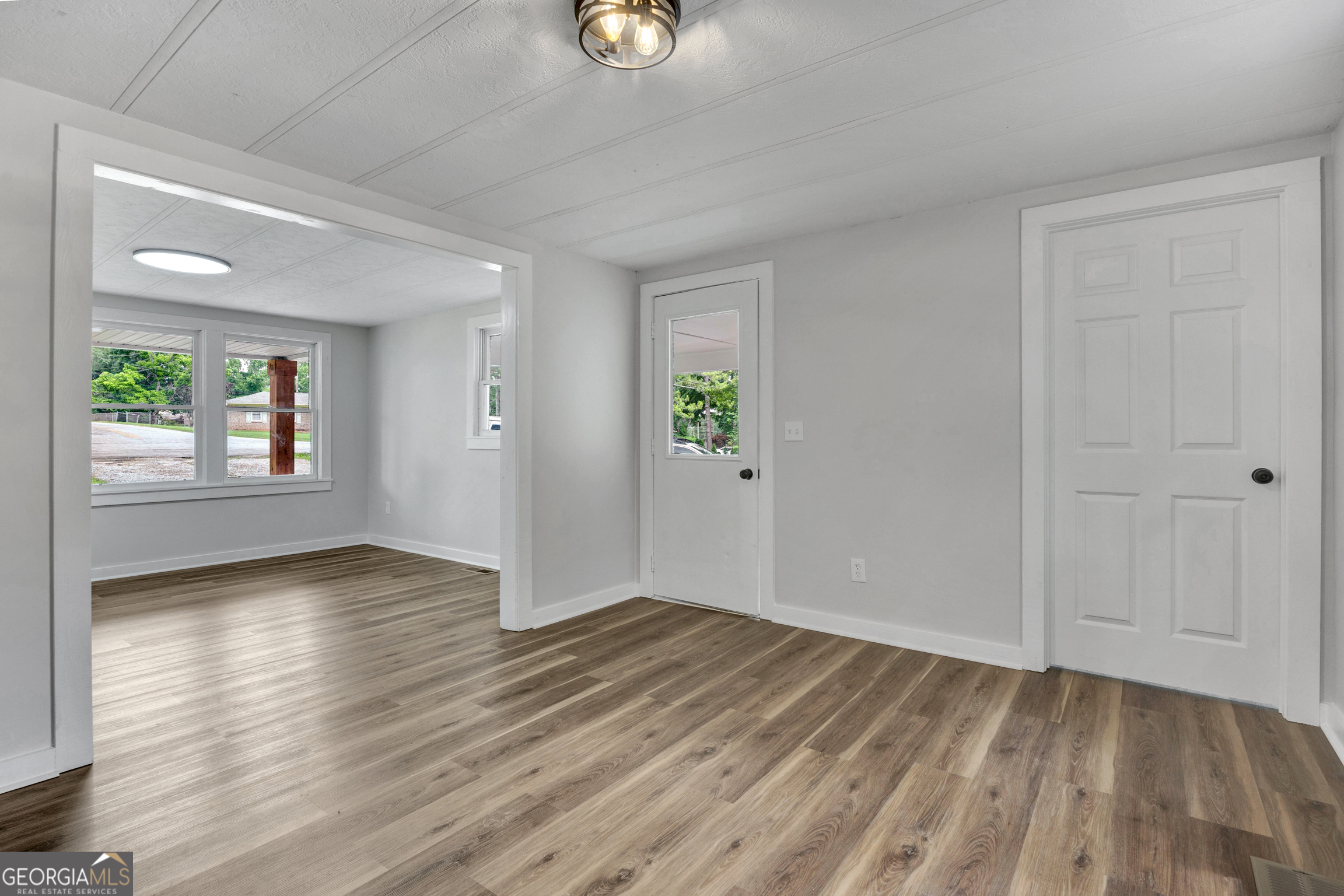 455 Cindy Street Jackson, GA 30233 - Photo 7 of 25 an empty room with wooden floor cabinet and windows
