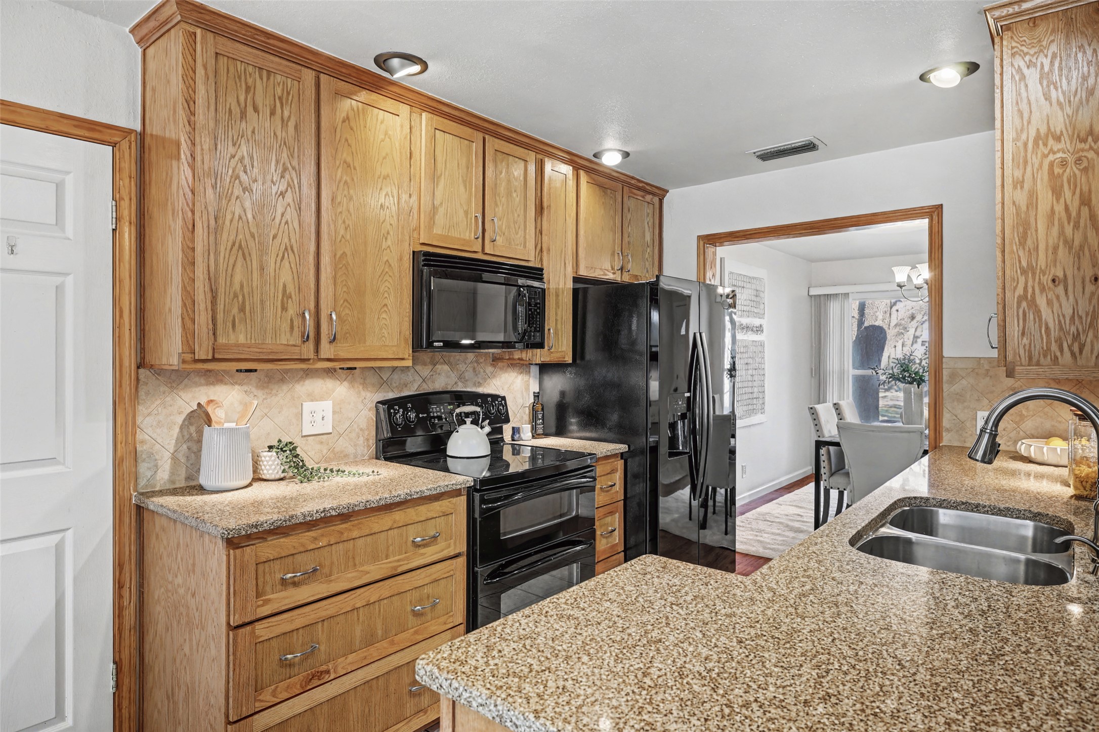 238 Mesa Drive Georgetown, TX 78628 - Photo 12 of 32 Kitchen featuring black electric range and refrigerator wood finish cabinets