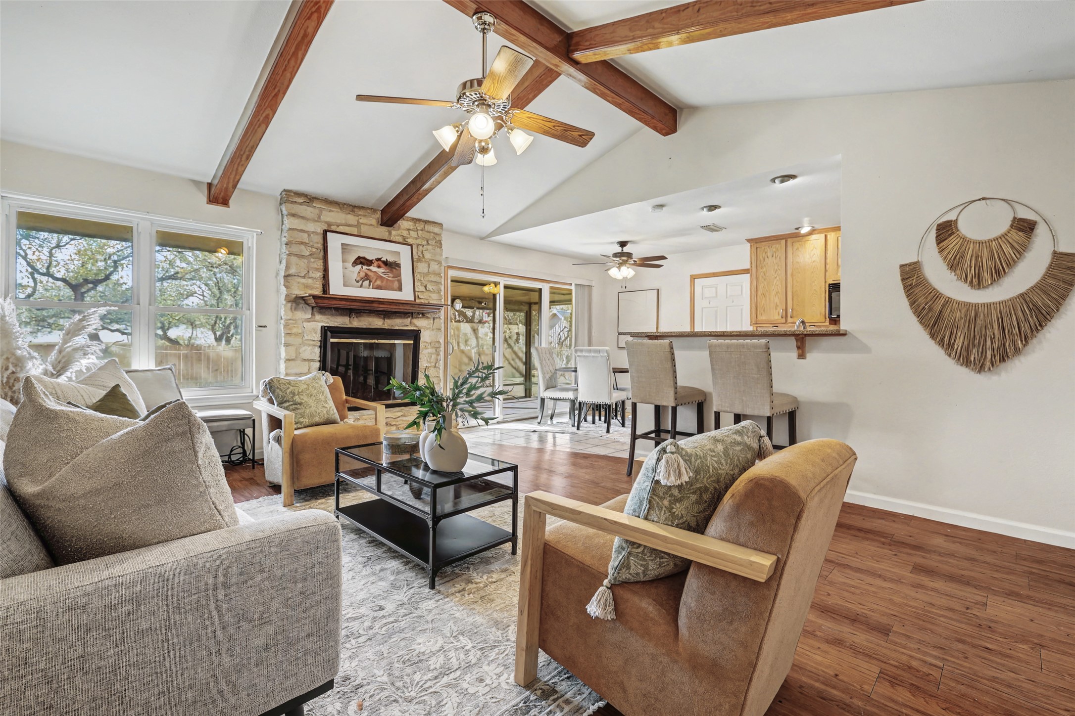 238 Mesa Drive Georgetown, TX 78628 - Photo 10 of 32 Living area with wood beamed ceiling, vinyl plank wood tone flooring, fireplace, and ceiling fan