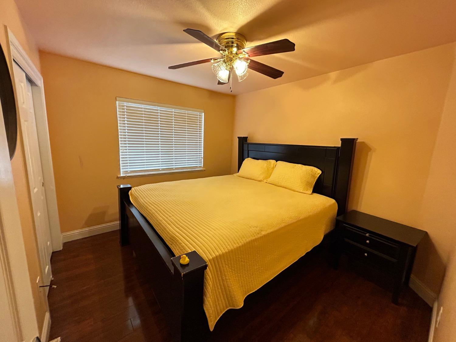 14039 West F Street Kerman, CA 93630 - Photo 13 of 19 a bedroom with a bed and a chandelier