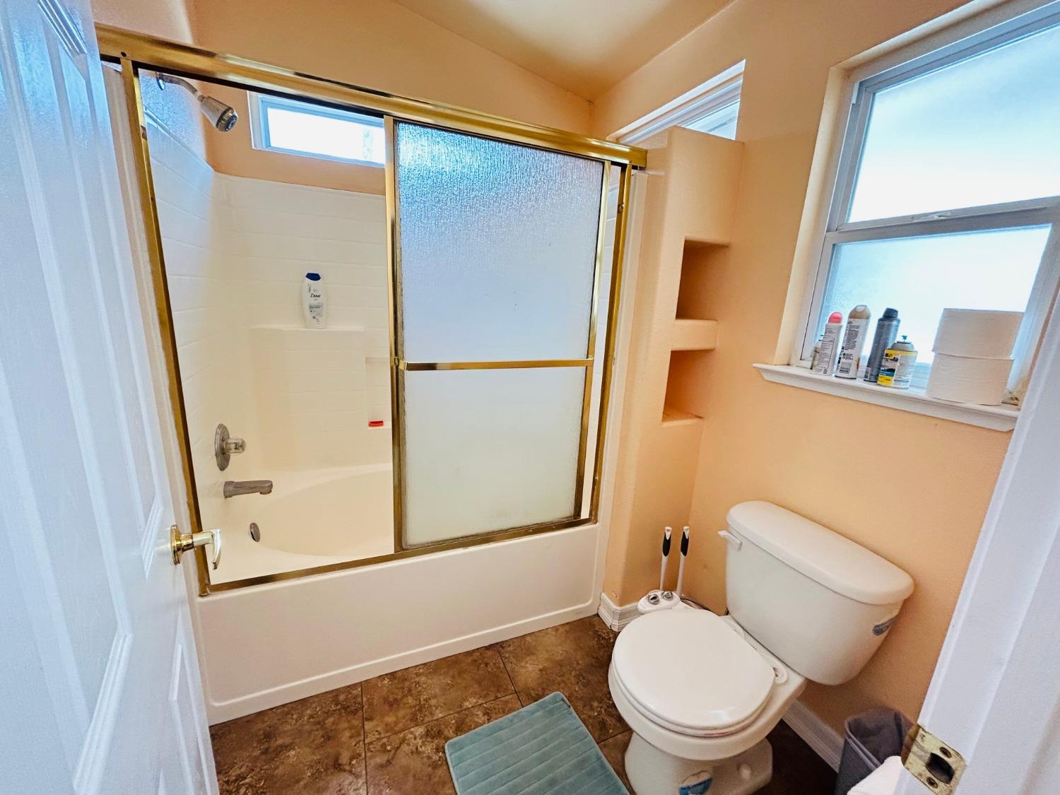 14039 West F Street Kerman, CA 93630 - Photo 16 of 19 a white toilet sitting next to a bathroom sink