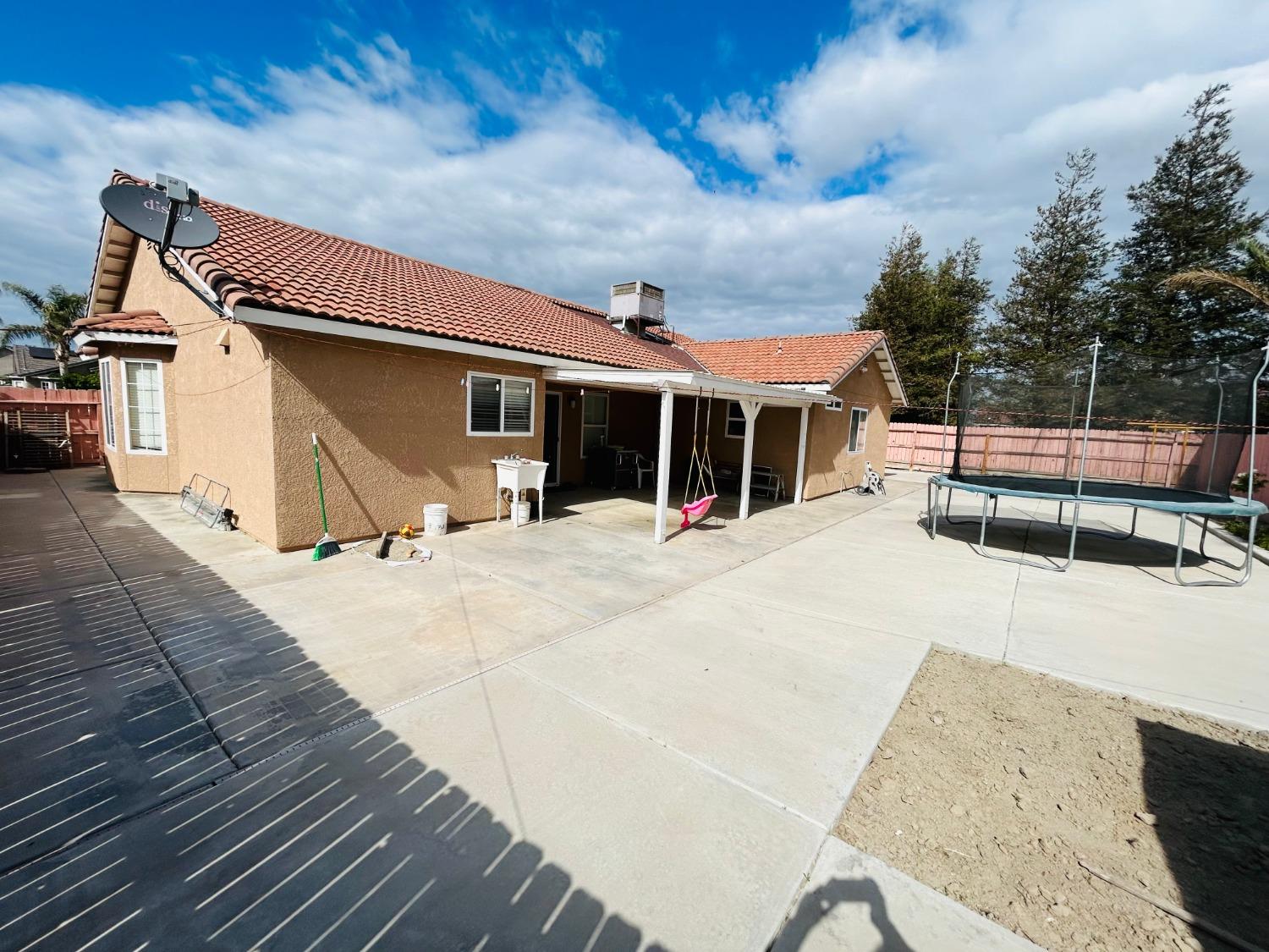 14039 West F Street Kerman, CA 93630 - Photo 17 of 19 a view of a house with a patio
