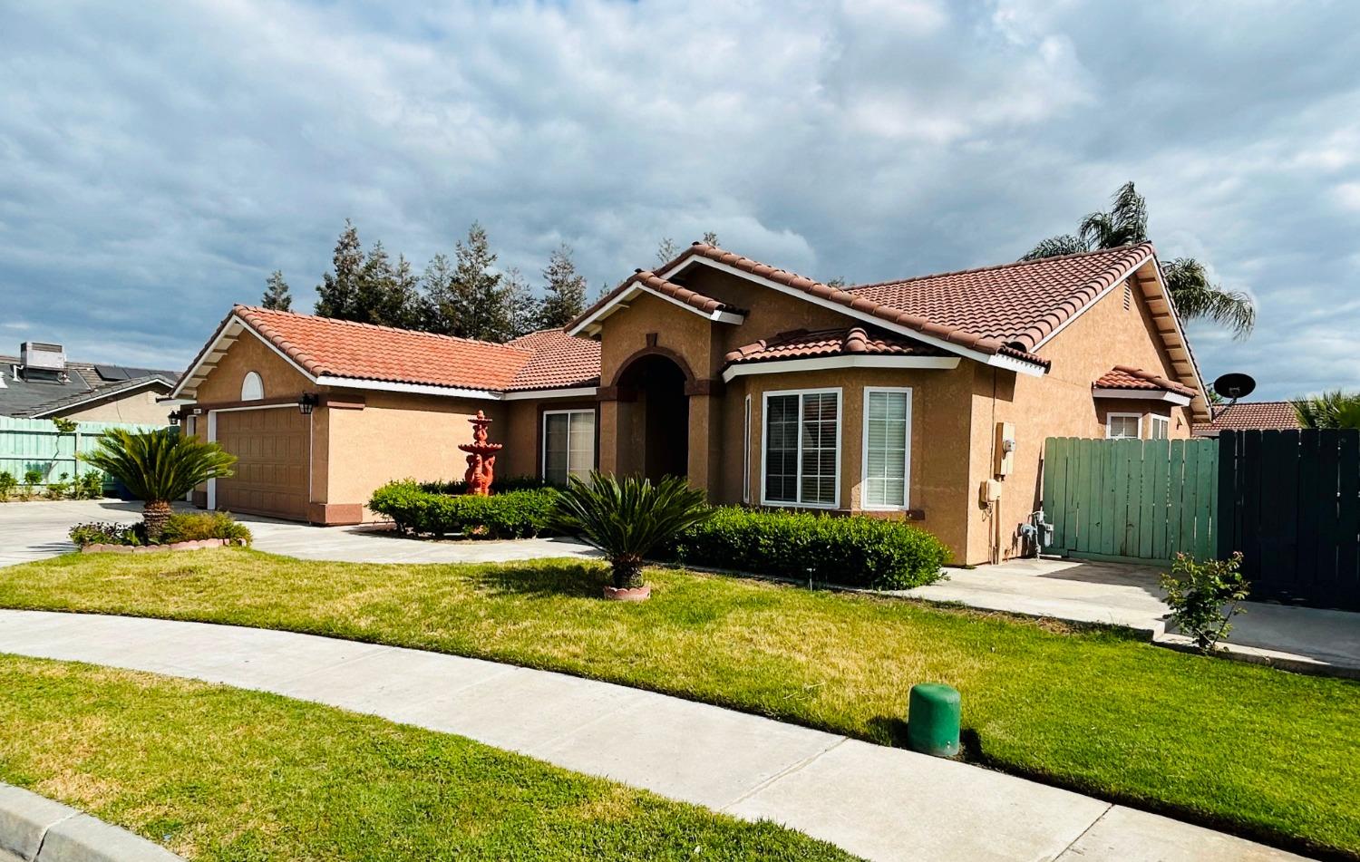 14039 West F Street Kerman, CA 93630 - Photo 3 of 19 a front view of a house with a yard