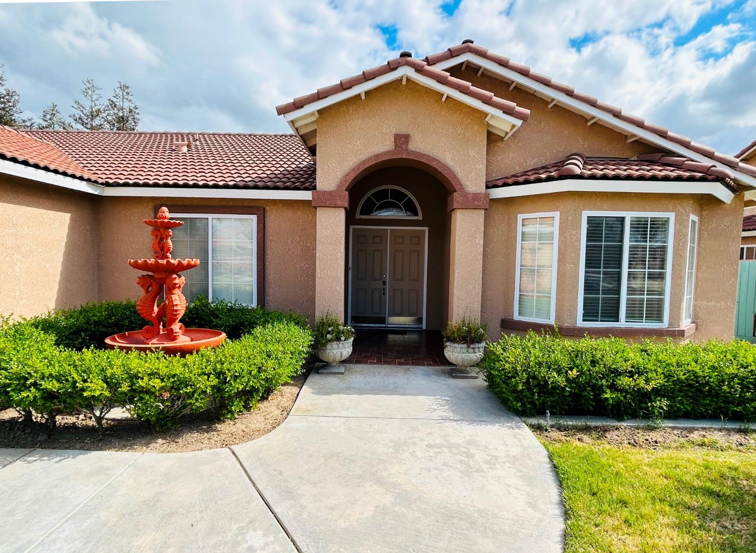 14039 West F Street Kerman, CA 93630 - Photo 5 of 19 a front view of a house with a yard