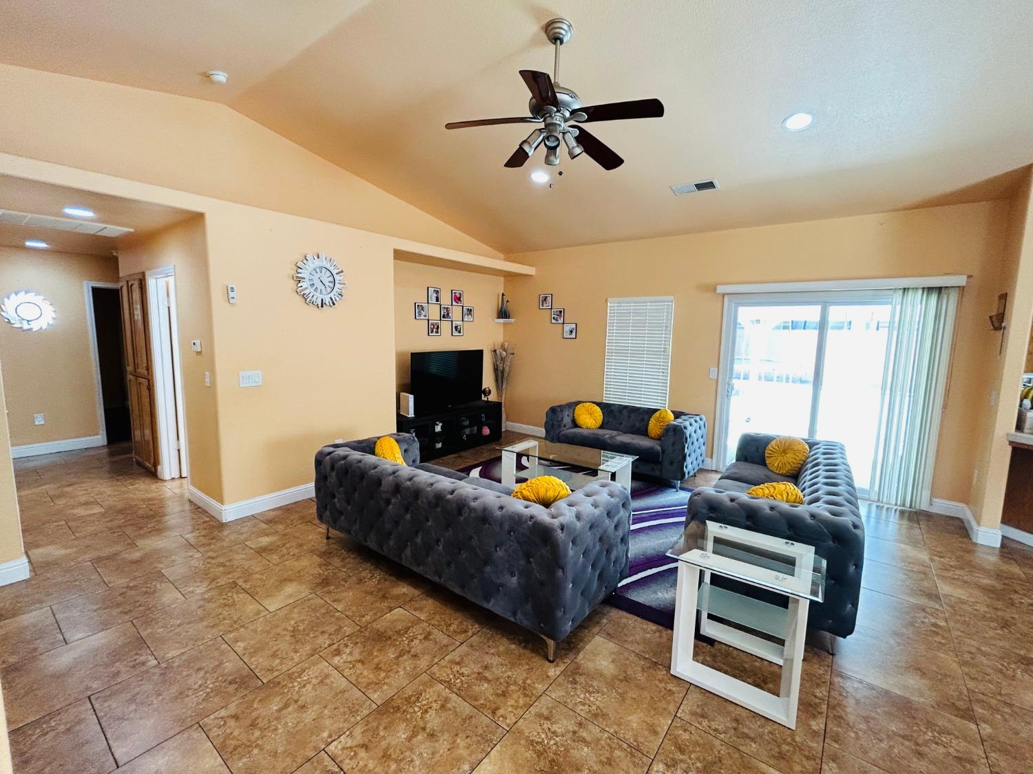 14039 West F Street Kerman, CA 93630 - Photo 6 of 19 a living room with furniture and a flat screen tv