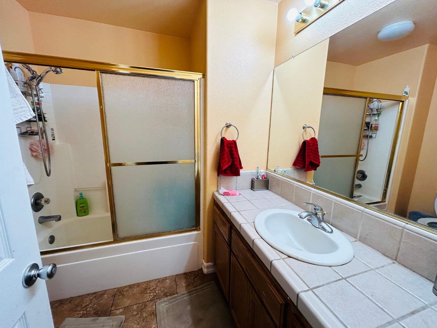 14039 West F Street Kerman, CA 93630 - Photo 10 of 19 a bathroom with a sink and a mirror