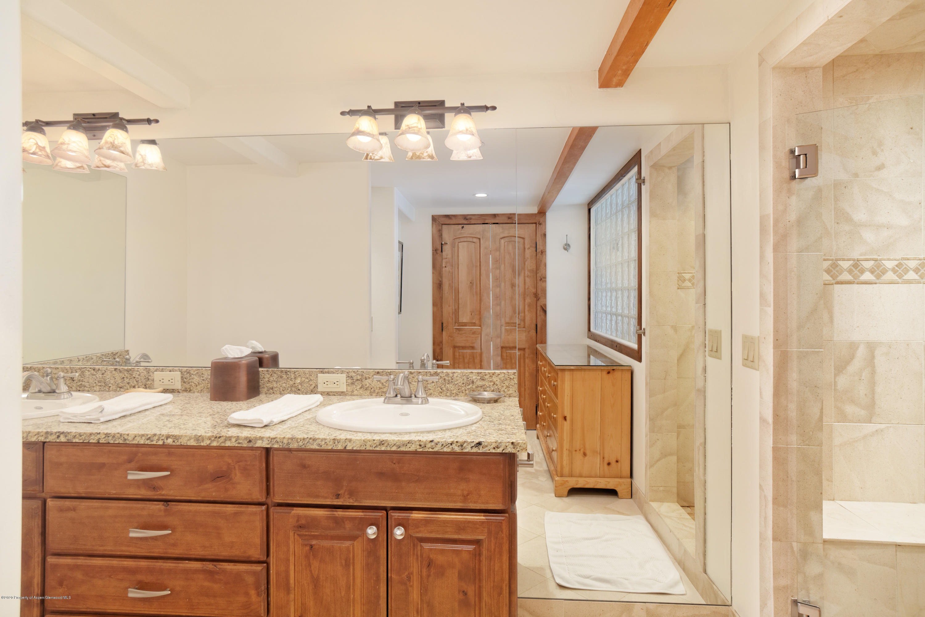 630 East Cooper Avenue, Unit 1 Aspen, CO 81611 - Photo 11 of 25 a bathroom with a granite countertop sink a mirror and a shower