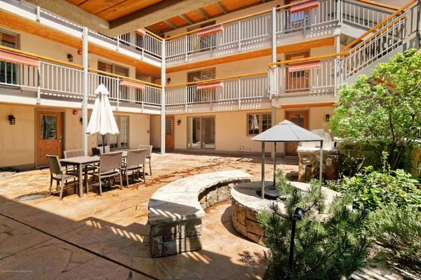 a view of a patio with table and chairs under an umbrella