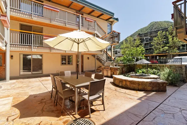a view of a patio with a table and chairs under an umbrella