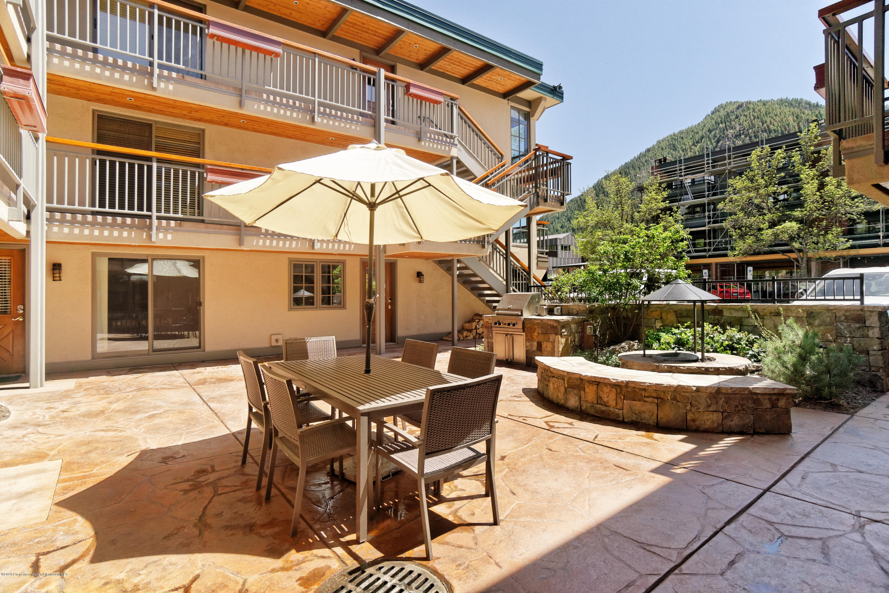 630 East Cooper Avenue, Unit 1 Aspen, CO 81611 - Photo 15 of 25 a view of a patio with a table and chairs under an umbrella