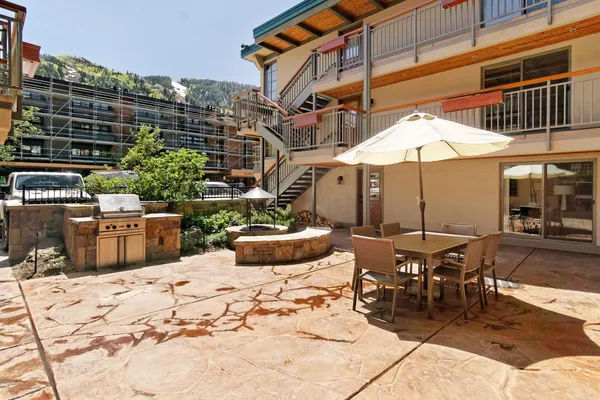 a view of a patio with a table and chairs under an umbrella