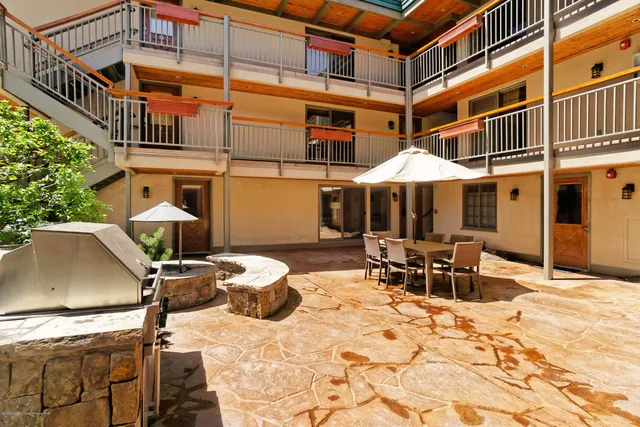 a patio with a table and chairs under an umbrella