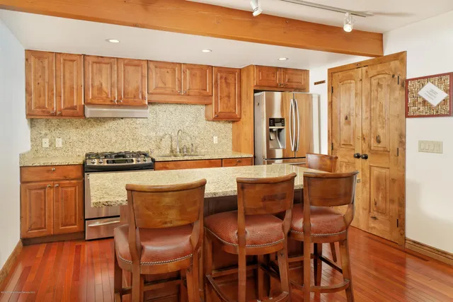 a kitchen with a table chairs refrigerator and cabinets
