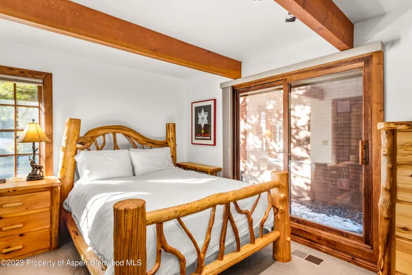 a bedroom with a bed and a large window with outer view