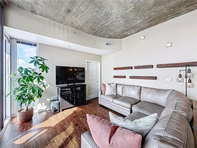 a bedroom with a bed and a flat tv screen on dresser