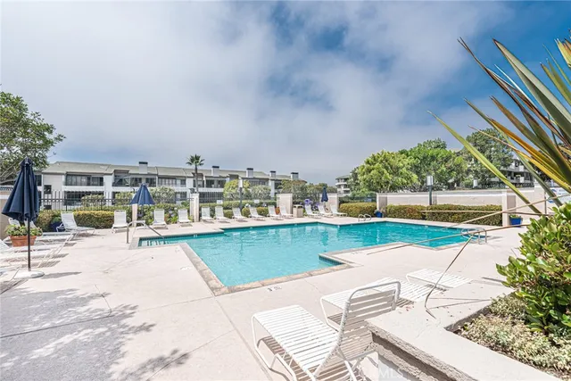 a view of a swimming pool with a patio and a yard