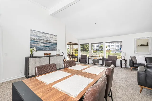 a living room with furniture a large window and kitchen view
