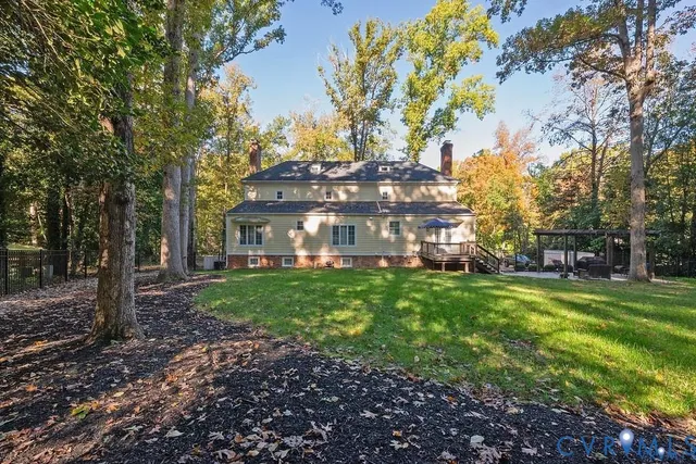 a view of a big house with a big yard and large trees