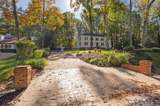a pathway of a house with a yard and sitting area