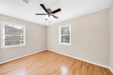 a view of a big room with wooden floor and windows
