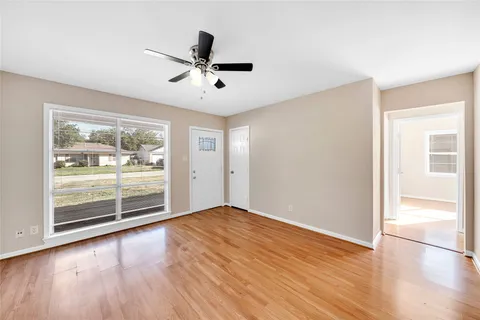a view of a livingroom with wooden floor and a ceiling fan