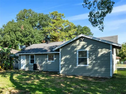 a view of a yard in front of a house with large tree