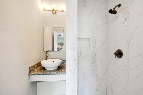 a bathroom with a granite countertop sink a toilet and shower