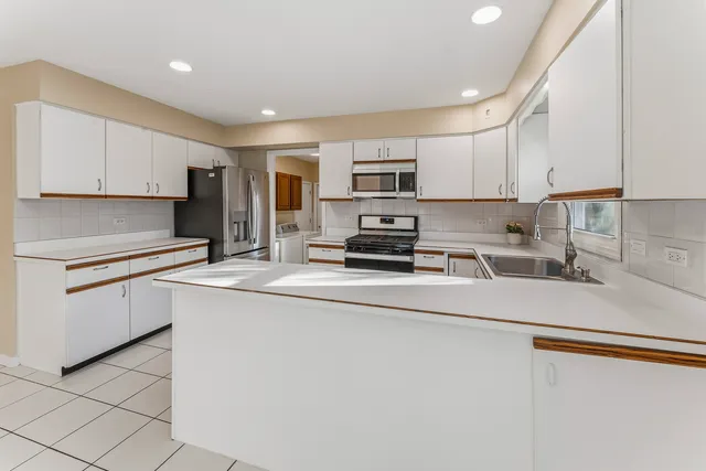 a kitchen with kitchen island granite countertop cabinets and white appliances