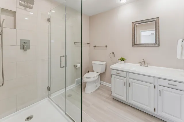 a spacious bathroom with a shower sink mirror and toilet