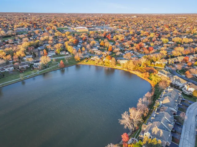 an aerial view of a houses with a lake