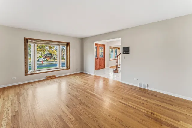 wooden floor in an empty room with a window
