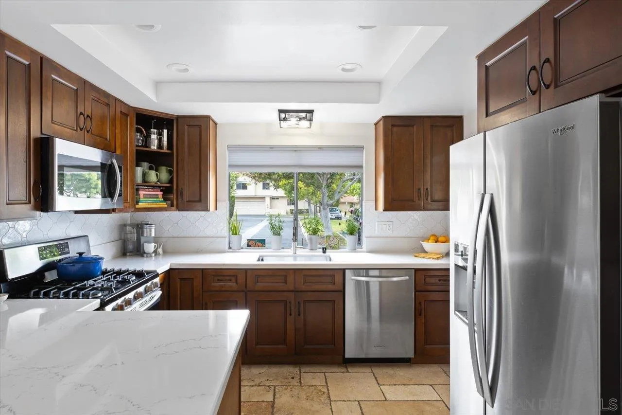 1763 Edgefield Lane Encinitas, CA 92024 - Photo 11 of 31 a kitchen with stainless steel appliances a refrigerator a sink a stove a washer dryer and cabinets
