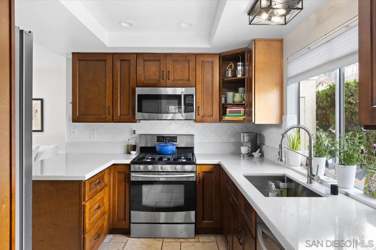 1763 Edgefield Lane Encinitas, CA 92024 - Photo 10 of 31 a kitchen with stainless steel appliances granite countertop a sink stove and microwave