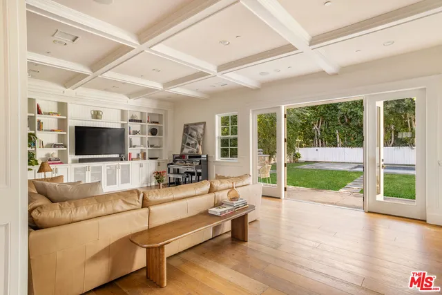 a living room with furniture tv and a floor to ceiling window