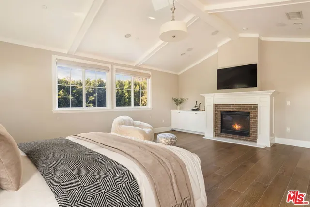 a bedroom with a large bed and a fireplace