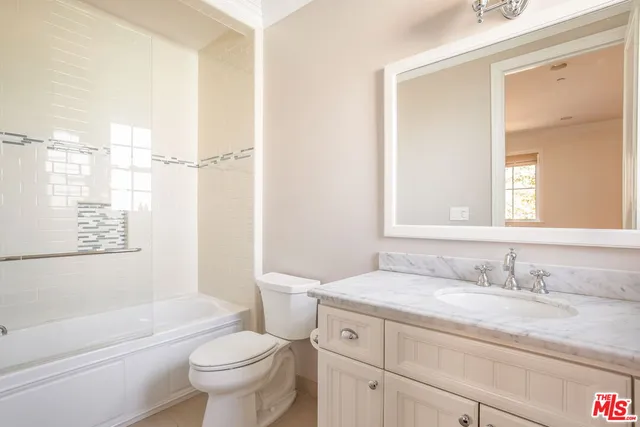 a bathroom with a granite countertop sink a toilet and a bathtub