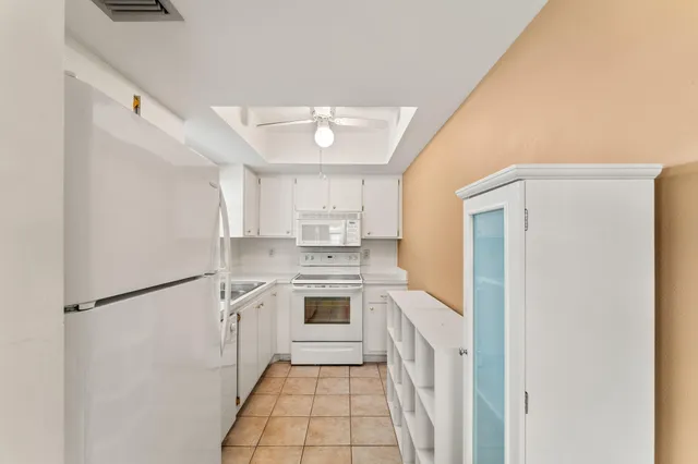 a kitchen with white cabinets and white appliances