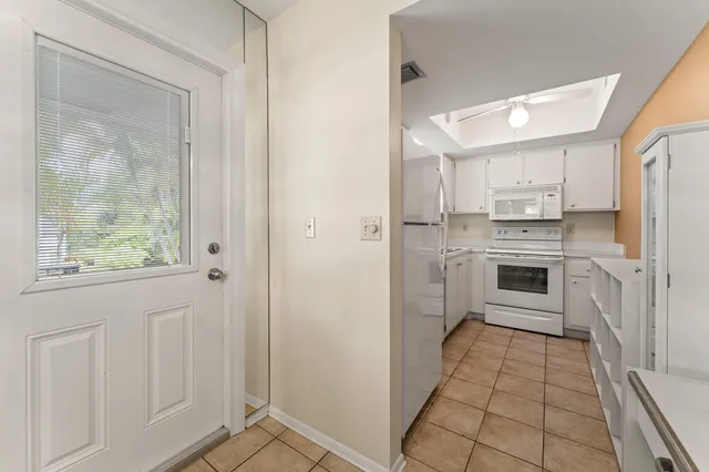 a kitchen with white cabinets and refrigerator