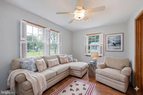a living room with furniture ceiling fan and a window