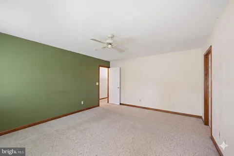 an empty room with a ceiling fan and a window