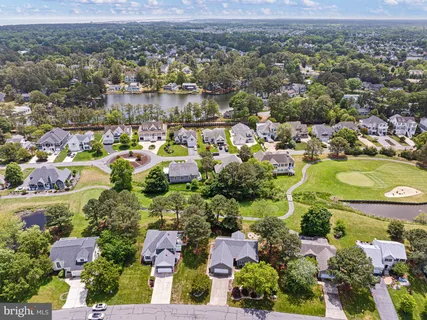 an aerial view of residential houses with outdoor space and trees